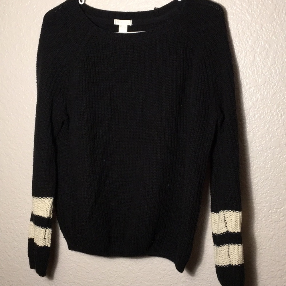 Black knit sweater with white striped sleeves.